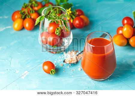 Glasses Of Fresh Delicious Jummy Red Tomato Juice And Fresh Raw Tomatoes With Pink Salt In Spoon On