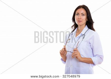 Studio Shot Of Young Beautiful Woman Doctor Thinking While Holdi