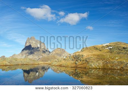 Midi Dossau Peak reflected in a lake. Ossau Valley, Pyrenees National Park, Pyrenees, France.
