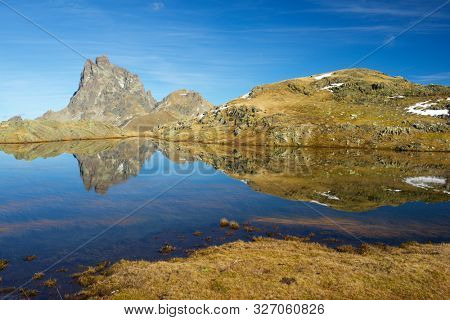 Midi Dossau Peak reflected in a lake. Ossau Valley, Pyrenees National Park, Pyrenees, France.