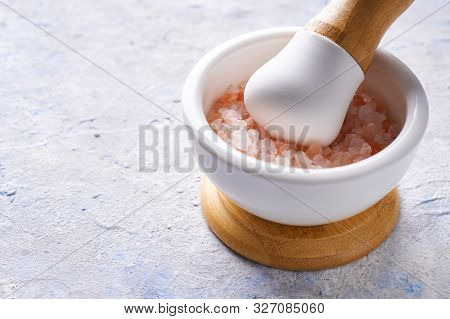 Pounder With Pink Sea Salt On Light Background Copy Space.