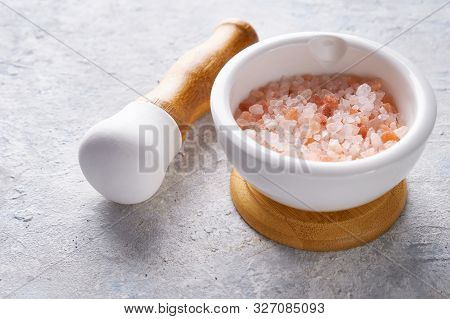 Pounder With Pink Sea Salt On Light Background Copy Space.