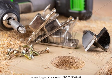 Installation Of Furniture Hinges In Chipboard. Small Carpentry Work In The Workshop.