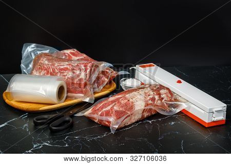 Vacuum Sealer Machine And Meat On A Dark Background.