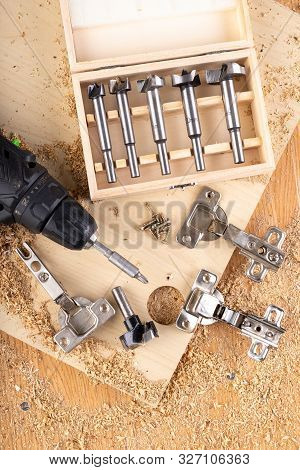 Installation Of Furniture Hinges In Chipboard. Small Carpentry Work In The Workshop.
