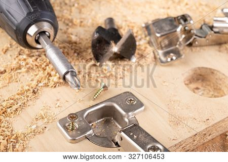 Installation Of Furniture Hinges In Chipboard. Small Carpentry Work In The Workshop.