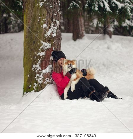 Portrait With A Cute Fluffy Puppy. Winter Walk With A Dog. Young Woman Walks With The Puppy, Snowy W