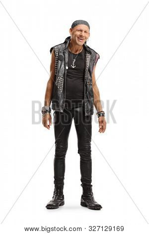 Full length portrait of a happy punker in a leather outfit smiling at the camera isolated on white background