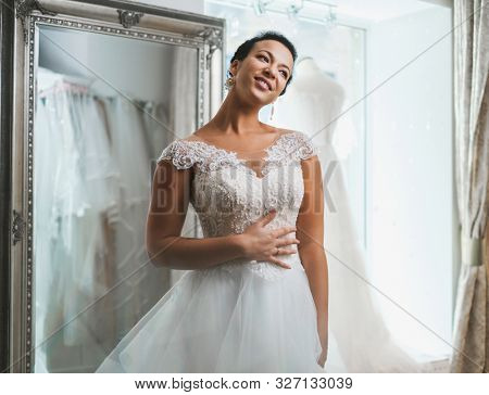 Beautifu bride choosing wedding dress in a wedding salon