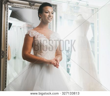 Beautifu bride choosing wedding dress in a wedding salon