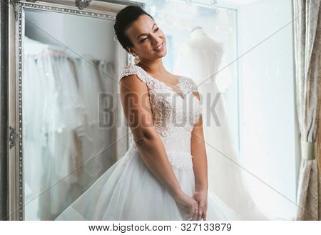 Beautifu bride choosing wedding dress in a wedding salon