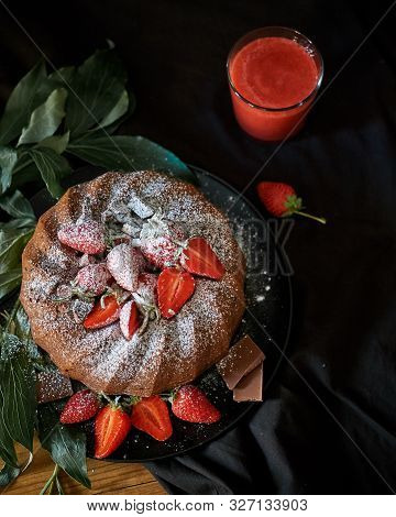 Chocolate Cake Light Brown With Red Strawberries. Cake Sprinkled With Powdered Sugar. Black Backgrou