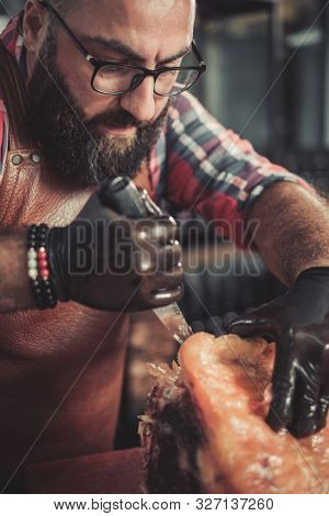 Chef cutting beef carcass in a restaurant