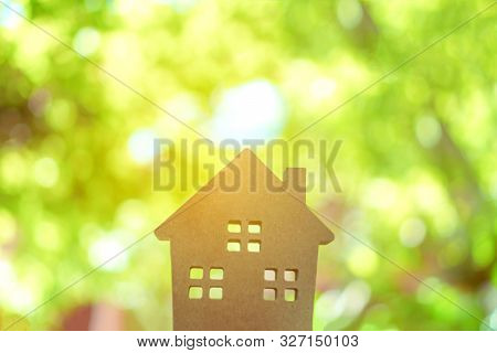 Closed Up Tiny Home Model On Floor Or Wood Board With Sunlight Green Bokeh Background. House Propert