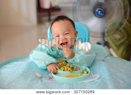 Happy Eating Asian Baby Boy, 7 Months Old Eating With Baby Led Weaning (blw) Method, Self-feeding