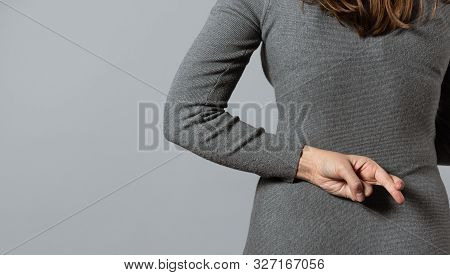 Liar Concept. Woman Talking Untruth And Holding Her Fingers Crossed Behind Her Back.