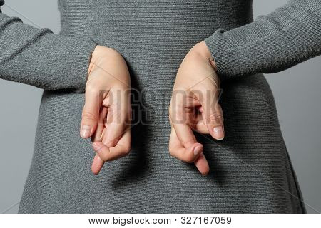 Liar Concept. Woman Talking Untruth And Holding Her Fingers Crossed Behind Her Back.
