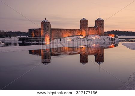View Of The Ancient Olavinlinna Fortress In March Lilac Twilight. Savonlinna, Finland