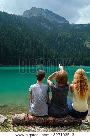 Family, Mother With Boy And Girl, Rest On Tree Log On Black Lake (crno Jezero) Shore, Summer Landsca