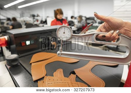 Woman Hands Use Leather Thickness Gauge On With A Natural Brown Leather. Preparing Of The Raw Materi