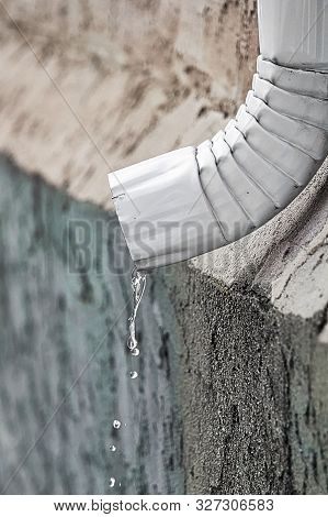 Water Flowing Out The End Of An Eavestrough