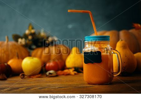 Pumpkins Juice In Bottles With Pumpkins. Two Glasses Cups Of Pumpkin Juice, Pumpkins And Fallen Ma. 