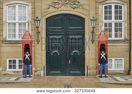 Military Officers Standing Guard Outside The Amalienborg Palace In Copenhagen, Denmark