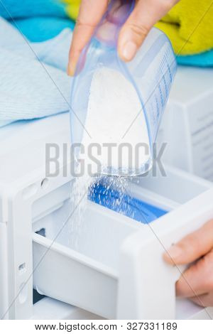 Washing Powder Detergent And Measuring Cup Pouring Into Machine. Household Duties, Clothes Laundry O