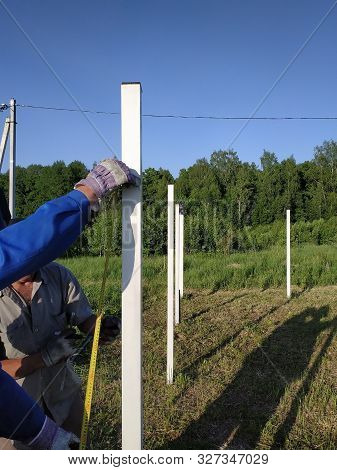 Metal Posts On A Fence In A Countryside Field.