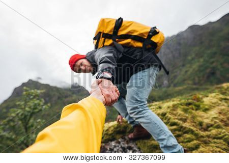 Group Of Two Active Tourist With Backpack Climb To Rock Helping Each Other. Brave Traveler Hold Hand