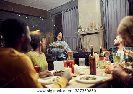 Portrait Of Excited Asian Woman Bringing Main Dish To Dinner Table During House Party With Friends, 