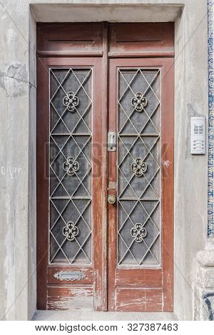 Wooden Door With Glass And Grid. Brown Front Door In Old Abandoned Facade. Weathered Double Wooden D