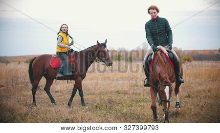 Two Women On The Horses Backs Are Walking