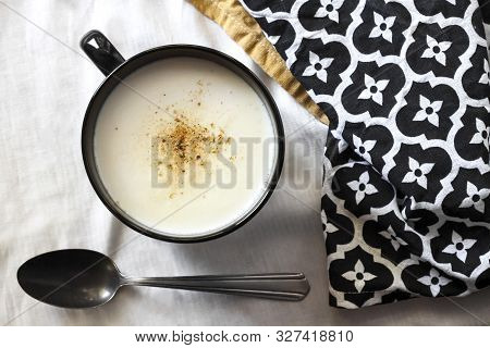 Cauliflower Soup (creme Du Barry) In Black Bowl On White Background With Black And White Cloth. Flat