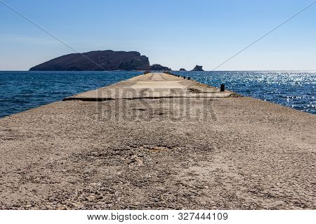 Empty Pier On Beach Greco With A View Of Saint Nikola Island In The Background In Budva, Montenegro