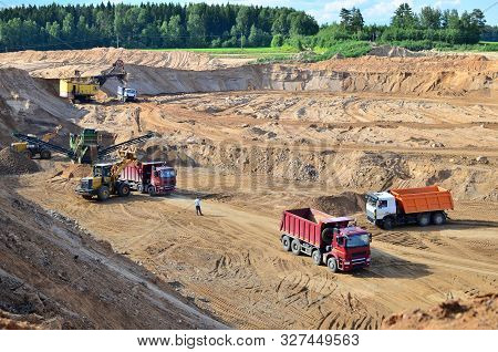 Wheel Front-end Loader Loads Sand Into A Dump Truck. Heavy Machinery In The Mining Quarry, Excavator