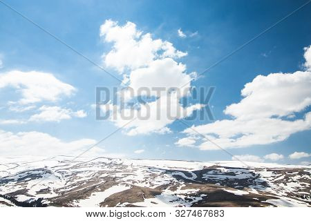 Lago Naki Spring Plateau With Snowy Hills, Blue Sky And Clouds
