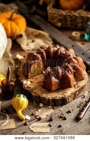 Tasty Homemade Baked Pumpkin Bundt Cake With Chocolate On Top Stands On Wooden Board On Rustic Table