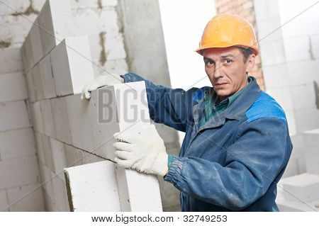 pedreiro de trabalhador de pedreiro de construção instalar tijolo de silicato de cálcio durante a criação da parede interior