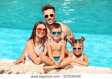 Happy Family In Swimming Pool On Sunny Day