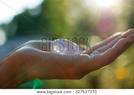 Female Hand With Transparent Amethyst Quartz Yoni Egg For Vumfit, Imbuilding Or Meditation. Shining 