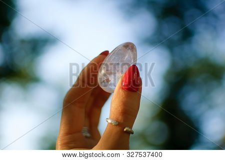 Female Hand With Transparent Amethyst Quartz Yoni Egg For Vumfit, Imbuilding Or Meditation. Shining 