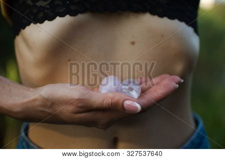 Female Hands Holding Two Yoni Eggs For Vumfit, Imbuilding Or Meditation Are Made From Pink Quartz An