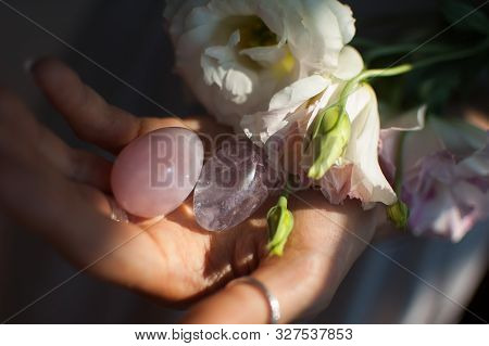 Female Hands Holding Two Yoni Eggs For Vumfit, Imbuilding Or Meditation Are Made From Pink Quartz An