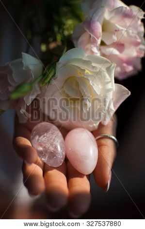 Female Hands Holding Two Yoni Eggs For Vumfit, Imbuilding Or Meditation Are Made From Pink Quartz An