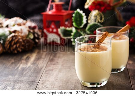 Homemade Eggnog With Cinnamon In Glass On Wooden Table. Typical Christmas Dessert. Copy Space
