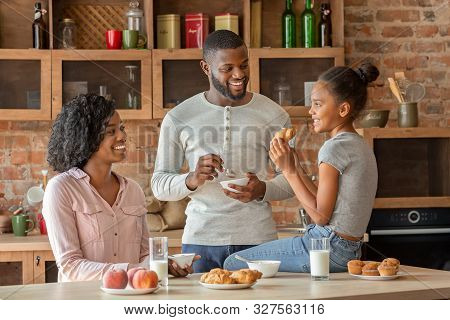 Positive African American Family Having Breakfast In Beautiful Kitchen, Talking While Eating, Free S