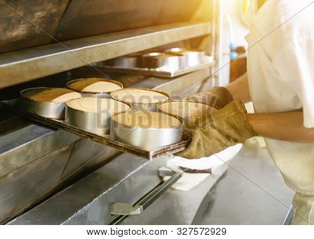 Male Cook Takes Cakes Out Of A Hot Oven For Making Cakes, Industry