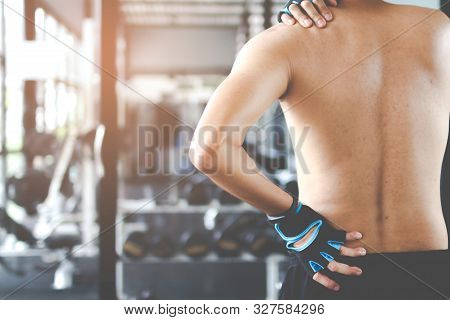 Man With Neck And Back Pain, Massage Of Male Body, Ache In Man's Body In The Gym Background.