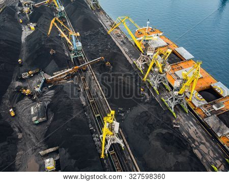 Loading Coal Anthracite Mining In Port On Cargo Tanker Ship With Crane Bucket Of Train. Aerial Top V
